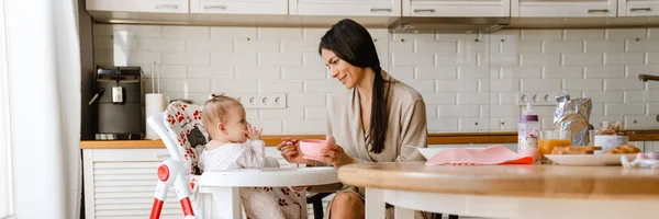 Mladá Brunetka Matka Usmívá Krmí Své Dítě Kuchyni Doma — Stock fotografie
