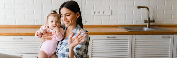 Madre Joven Gesticulando Sosteniendo Bebé Mientras Trabaja Con Ordenador Portátil —  Fotos de Stock