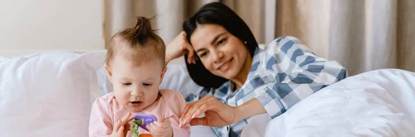 Young Mother Smiling Playing Her Baby While Lying Bad Home — Stock Photo, Image