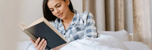 Genç Spanyol Kadın Evde Yatarken Kitap Okuyor — Stok fotoğraf