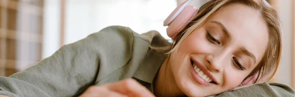 Νεαρή Γυναίκα Χαμογελά Ακούγοντας Μουσική Κινητό Και Ακουστικά Στο Σπίτι — Φωτογραφία Αρχείου