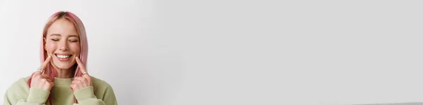 Молодая Улыбающаяся Женщина Розовыми Волосами Указывая Пальцем Щеку Изолированы Белом — стоковое фото