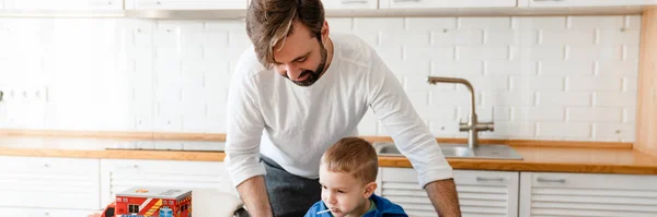 中年白人父亲和他的儿子蹒跚学步 在厨房桌上吃早餐 快乐极了 — 图库照片