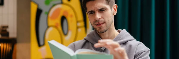 Jeune Homme Souriant Lit Livre Tout Étudiant Dans Café Intérieur — Photo