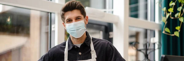 Young Man Apron Wearing Protective Medical Mask Standing Cash Register — Stock Photo, Image