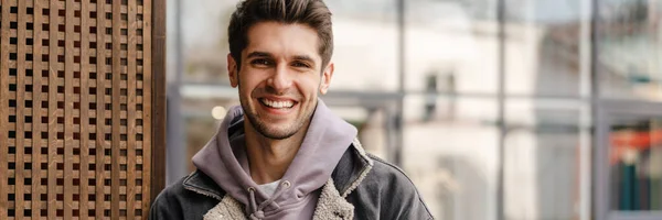 Hymyilevä Nuori Valkoinen Mies Rento Cothes Käyttäen Matkapuhelimen Ulkona Kaupungissa — kuvapankkivalokuva