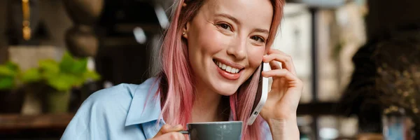 Mladá Usměvavá Žena Mluví Mobilním Telefonu Při Pití Kávy Kavárně — Stock fotografie