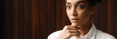 Young black woman standing and looking aside indoors