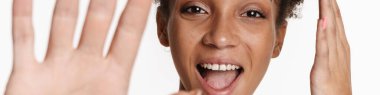 Young black woman in tank top laughing and gesturing at camera isolated over white background