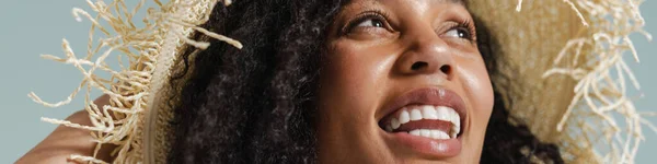 Czarna Kobieta Słomkowym Kapeluszu Uśmiechnięta Patrząca Górę Odizolowana Niebieskim Tle — Zdjęcie stockowe