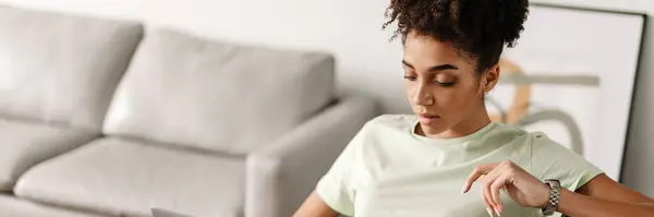 Young Black Woman Working Laptop While Sitting Armchair Home — kuvapankkivalokuva