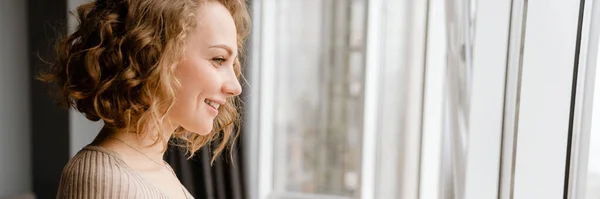 Mujer Rubia Joven Sonriendo Mientras Usa Teléfono Móvil Casa — Foto de Stock