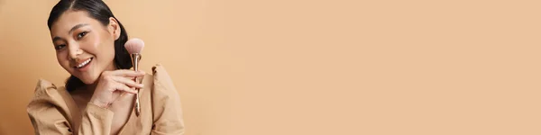 Молодая Азиатская Брюнетка Улыбается Позируя Пудрой Кисти Изолированы Бежевом Фоне — стоковое фото