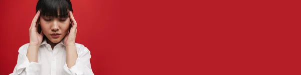 Молода Азіатка Сорочці Головним Болем Потирає Храми Ізольовано Червоному Тлі — стокове фото