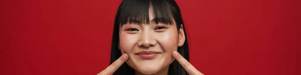 Genç Asyalı Kadın Gülümsüyor Kırmızı Arka Planda Izole Edilmiş Yanaklarını — Stok fotoğraf