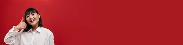 Молода Азіатка Сорочці Посміхається Показує Великий Палець Вгору Ізольовано Червоному — стокове фото