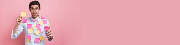 Счастливая брюнетка среднего возраста мужчина в рубашке стоял покрытый постом это наклейки на розовый фон стены