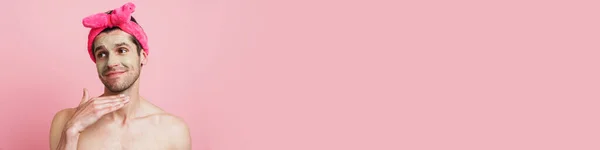 Молодой Мужчина Рубашки Повязке Улыбается Смотрит Сторону Изолированы Розовом Фоне — стоковое фото