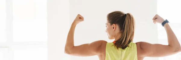 Sorrindo Mulher Fitness Mostrando Seu Bíceps Ginásio Frente Grande Janela — Fotografia de Stock