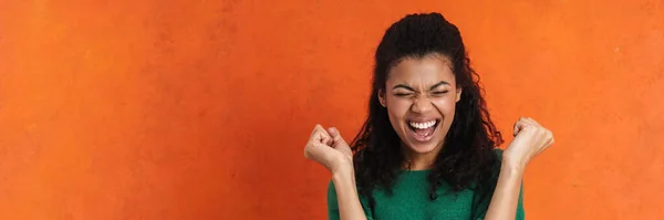 Lykkelig Ung Afrittisk Kvinne Fritidsklær Som Står Oransje Bakgrunn Feirer – stockfoto