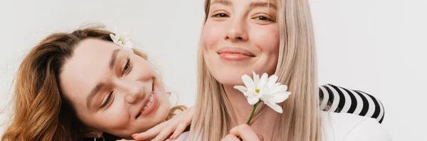 Nuori Valkoinen Kaksi Naista Halaus Hymyilevä Poseeratessaan Kukkia Eristetty Valkoisella — kuvapankkivalokuva