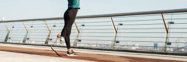 Protezli genç sporcu kadın şehir köprüsünde çalışırken egzersiz yapıyor.