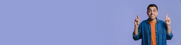 Молодий Брюнетка Людина Посміхається Тримає Пальці Схрещені Ізольовані Фіолетовому Фоні — стокове фото
