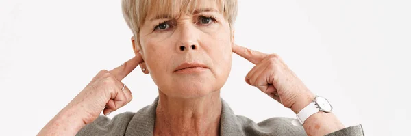 Ευρωπαϊκή Ώριμη Γυναίκα Συνοφρυώνεται Και Κλείνει Αυτιά Της Απομονωμένη Λευκό — Φωτογραφία Αρχείου