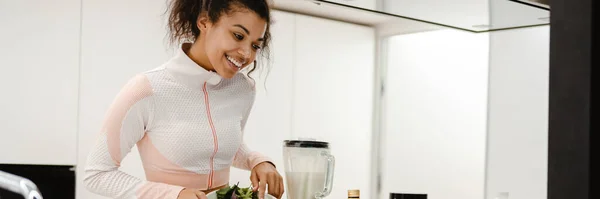 Schwarze Frau Lacht Und Benutzt Laptop Beim Kochen Hause Stockfoto