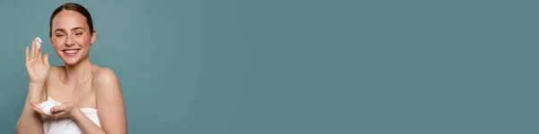 Імбир Жінка Рушнику Посміхається Показуючи Косметичну Піну Ізольовано Синьому Фоні — стокове фото