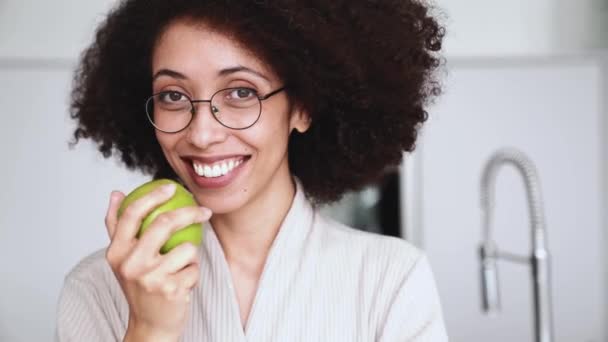 Šťastná Africká Žena Brýlích Županu Drží Jablko Dívá Kameru Kuchyni — Stock video