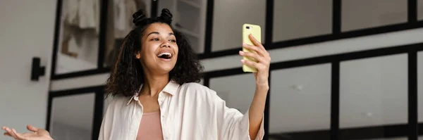 Ung Lykkelig Amerikansk Kvinne Med Smarttelefon Som Lager Blogg Hjemmefra – stockfoto