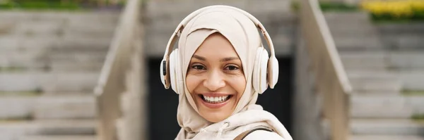 Ближневосточная Женщина Хиджабе Слушает Музыку Беспроводными Наушниками Открытом Воздухе — стоковое фото