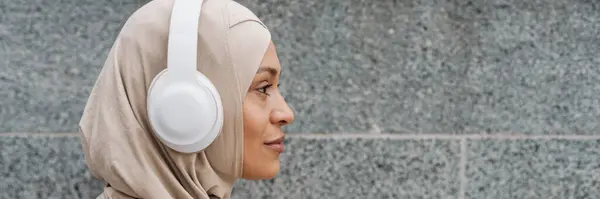 Lähi Idän Nainen Hijabissa Kuuntelemassa Musiikkia Langattomilla Kuulokkeilla Ulkona — kuvapankkivalokuva