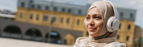 Donna Mediorientale Hijab Sorridente Mentre Ascolta Musica Con Cuffie Wireless — Foto Stock