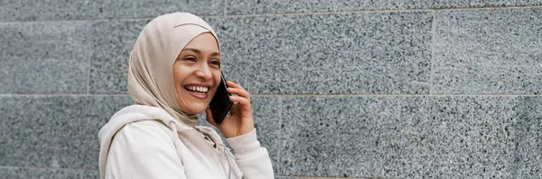 Lähi Idän Nainen Hijabissa Hymyilee Puhuessaan Kännykkään Ulkona — kuvapankkivalokuva