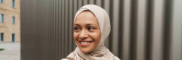 Hymyilevä Keski Ikäinen Musliminainen Urheiluvaatteissa Kävely Kadulla — kuvapankkivalokuva