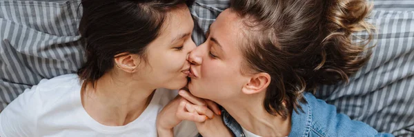 Portret Całującej Lesbijki Pary Dziewczyn Trzymających Się Ręce Łóżku Świetlicy — Zdjęcie stockowe
