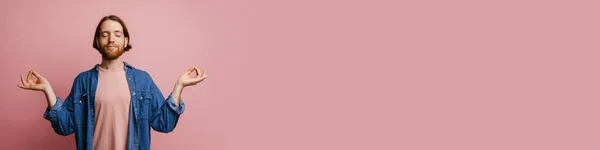 Молодий Імбирний Чоловік Жестом Бороди Під Час Медитації Ізольований Рожевому — стокове фото