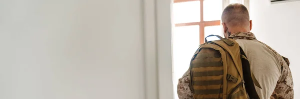 Hvit Militær Mann Iført Uniform Stående Med Ryggsekk Hjemme – stockfoto