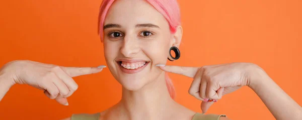 Młoda Biała Kobieta Różowymi Włosami Wytykająca Palcami Swój Uśmiech Pomarańczowym — Zdjęcie stockowe
