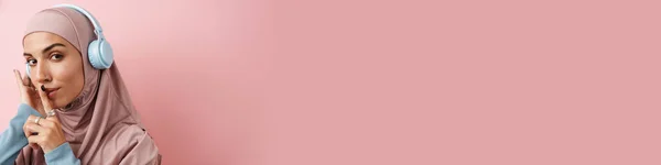 Портрет Уверенной Мусульманки Розовом Хиджабе Наушниках Жестом Молчания Розовой Студии — стоковое фото