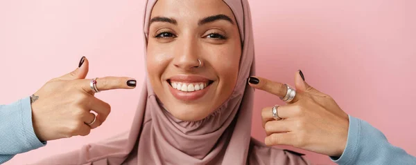 站在粉红工作室时 一个戴着粉色头巾 面带微笑的穆斯林妇女的画像展现了她的笑容 — 图库照片