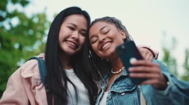 Yazın sokakta cep telefonuyla selfie çeken çok kültürlü tatlı bayan arkadaşlar.