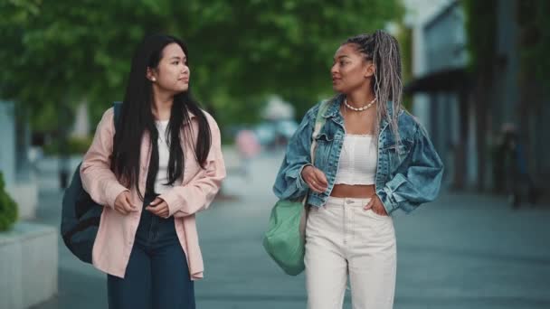 かなり多文化な女性の友人が話し 夏の路上で歩いています — ストック動画