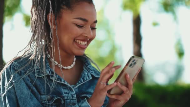 Mulher Africana Alegre Com Tranças Cabeça Mensagens Texto Celular Parque — Vídeo de Stock