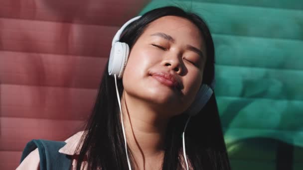 Ontspannen Brunette Aziatische Vrouw Luisteren Muziek Hoofdtelefoon Met Gesloten Ogen — Stockvideo