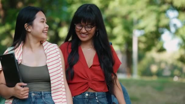Positieve Aziatische Vrouwelijke Studenten Praten Knuffelen Tijdens Het Wandelen Buiten — Stockvideo