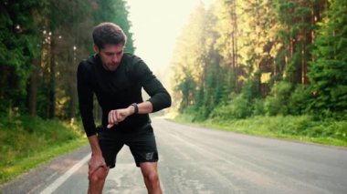 Yakışıklı esmer sporcu dinlenmek için durur ve sabah ormanda koşuya başlar.