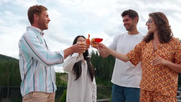 夏のバルコニーでマウンテンリゾートでカクテルを飲むハッピーな多国籍の友人 — ストック動画